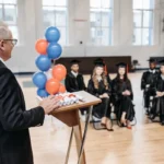 Upacara kelulusan sekolah dengan pembicara menyampaikan pidato di podium